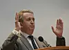 Terje Rød-Larsen taler ved en talerstol med begge hendene løftet.