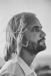 Svart-hvitt sideprofil av Einar Stenseng, en skjeggete mann med langt hår og lys skjorte.