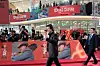 Tom Cruise vinker på en rød løper foran plakater for filmen «Digger» i Seoul.