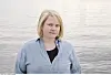 Portrett av Ida Fjeldbraaten i blågrå skjorte står foran rolig vann.
