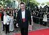 Den danske regissøren Lars von Trier (i midten) går opp den røde løperen før den offisielle visningen av filmen hans, Idiotene. Von Triers film var en av 22 bidrag som konkurrerte om Gullpalmen under den 51. filmfestivalen i Cannes.