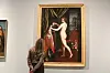 Besøkende ser på et klassisk maleri i et museumsgalleri.