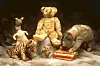 Kosedyrene Kanga, Winnie the Pooh, Eeyore, Piglet og Tigger står samlet rundt bøker.
