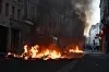 Brennende søppel og tett røyk i en mørk gate i Paris.