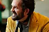 Nærbilde av Thomas Dybdahl med skjegg, sennepsgul jakke og skjerf.