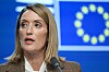 Roberta Metsola taler i en mikrofon foran et EU-flagg under et toppmøte i Brussel.