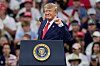 Donald Trump taler ved et podium med USAs presidentsegl foran en folkemengde i Florida.
