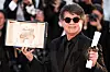Jafar Panahi i svart antrekk holder et innrammet dokument og en pris under Cannes-festivalen.